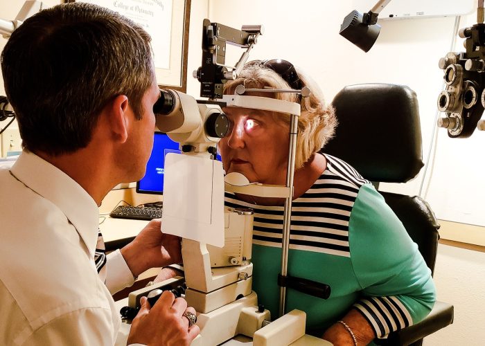 Active babyboomer woman getting her annual eye exam done by a professional checking her eye pressure
