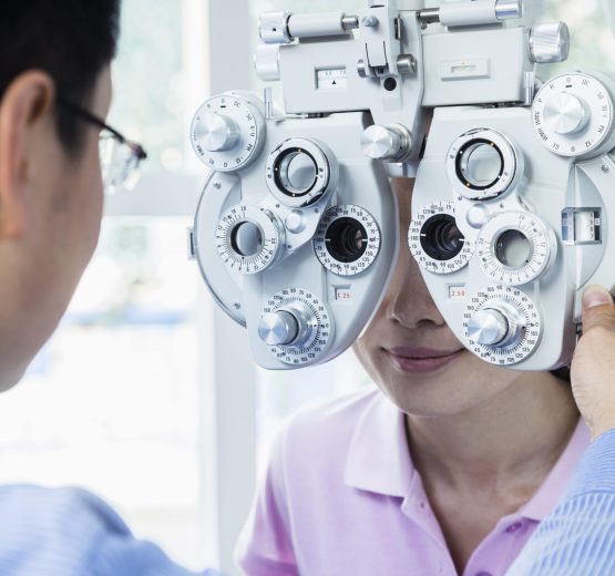 Optometrist doing an eye exam on young woman